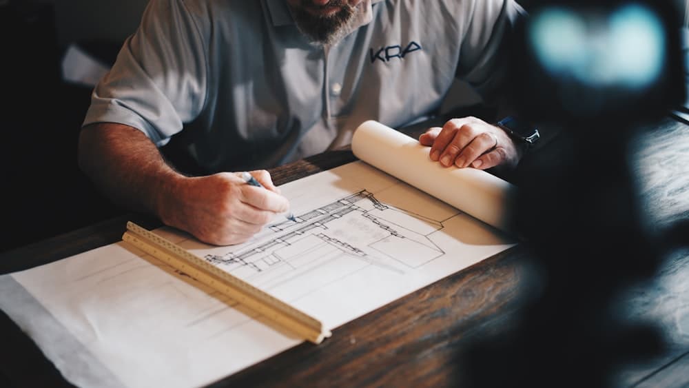 Bedrock general contractor reviewing architectural blueprints for a Waco, TX design–build project